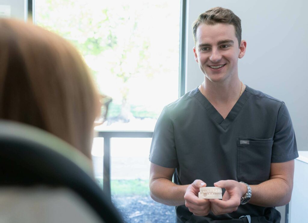 Dr. David Van Huffel explaining treatment with teeth model.